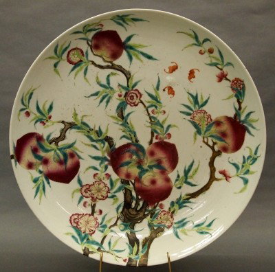 Chinese porcelain charger: A large Chinese porcelain charger. Polychrome decoration with a Pomegranate tree in blossom with flying Bats on front and back. Blue underglaze painted mark. Minor wear. 18 1/4" diameter. ESTIMATE $60