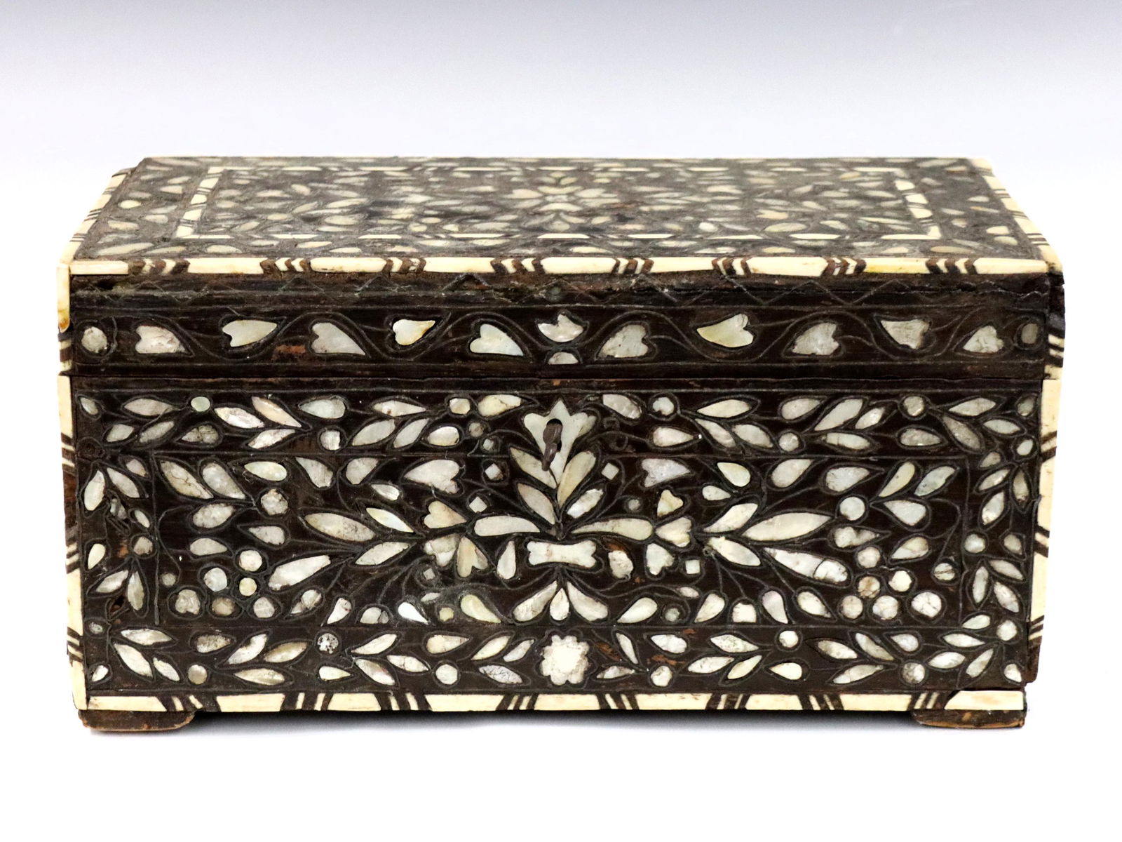 Islamic Inlaid MOP & Bone Box: An Islamic inlaid box. Hardwood construction with inlaid Mother of Pearl floral decoration and geometric Bone border. Hinged lid opens to reveal an inlaid mirror and box with three compartments. Origi