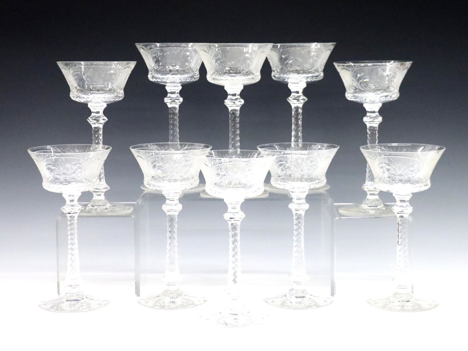 10 Cut Crystal Wine Glasses: Ten early 20th century Cut Crystal wine glasses. Flared cup with hexagonal stem and cut floral decoration. Two with small flakes to rim. Each 7 3/4" high. ESTIMATE $200-400
