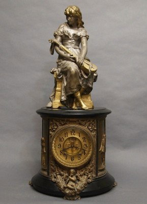 Ansonia Figural Iron clock: A late 19th century Ansonia "Indiana" model Iron clock with figure. 8-day time and strike movement with open escapement and Brass dial. Enamenled Iron case with Spelter figure. Older repaint with some