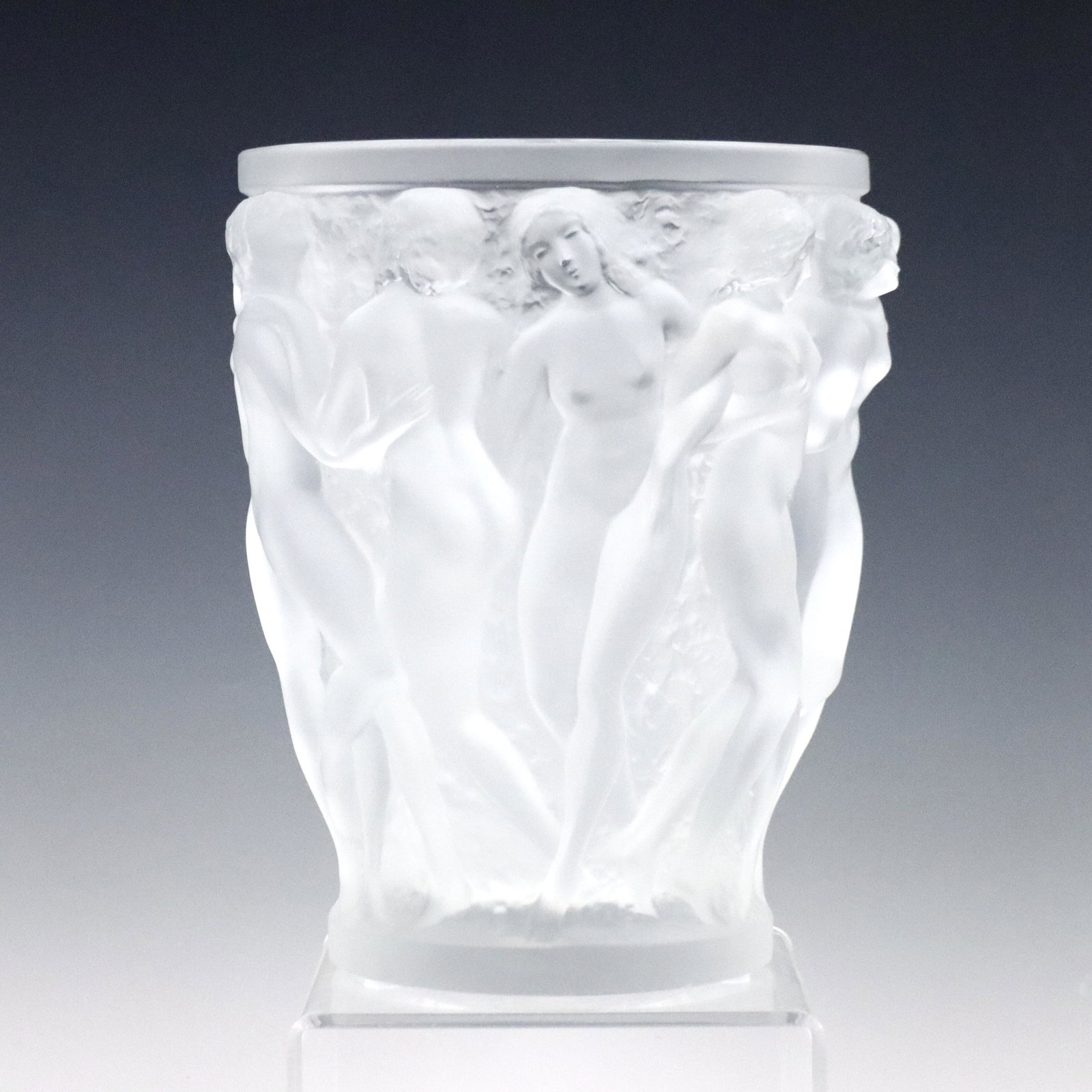 Lalique Bacchantes Vase: A mid 20th century Lalique frosted Crystal "Bacchantes" vase. Neoclassical design depicting nude figures. Etched "Lalique France" signature and original sticker. Slight wear. 9 3/4" high. ESTIMATE $1,