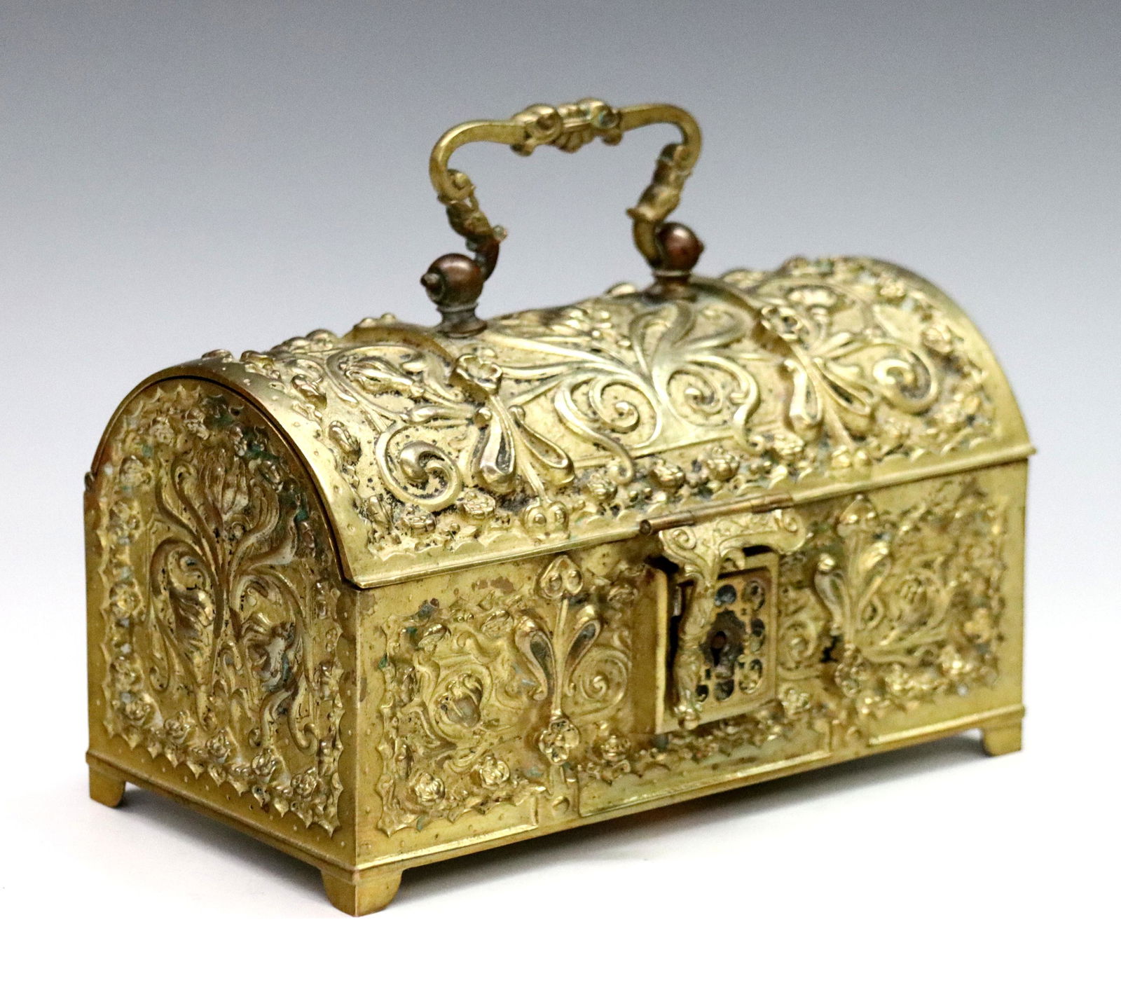 German Jugendstil Jewelry Casket: A turn of the century German Jugendstil Bronze jewelry casket. Hinged dome-top Gilt Bronze box with floral design on bracket feet. Some surface wear and pitting, monogrammed at underside. 6 1/2" long.
