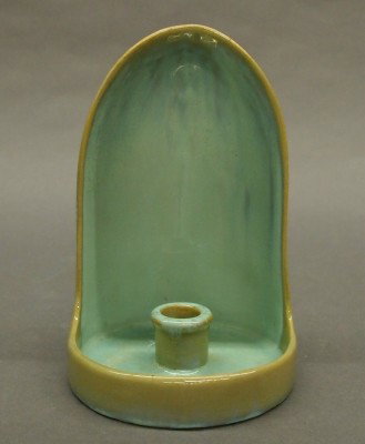 Fulper Pottery chamber stick: A 20th century Fulper Art Pottery chamber stick. Hooded design with scrolled handle in a Tan/Green glaze. Stamped vertical "Fulper" mark. Slight surface wear. 7 1/2" high. ESTIMATE $100-150