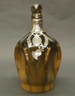 Fulper Pottery musical decanter: A 20th century Fulper Art Pottery musical decanter. Pinched body with Cat's eye glaze and Sliver overlay. Unmarked. Slight surface wear. 710" high. ESTIMATE $100-200