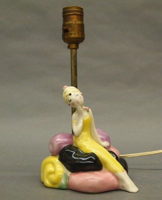 Fulper Pottery lamp: A 20th century Fulper "Fish" figural lamp. Woman sitting on rocks. Stamped vertical mark, and stamped "Fish". Slight wear. 10 1/2" high overall. ESTIMATE $100-200