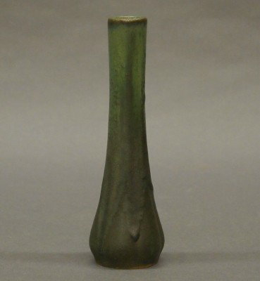 Fulper Pottery vase: A 20th century Fulper Art Pottery bud vase. Molded design with a straight neck in a Green speckled glaze. Stamped vertical "Fulper" mark. Minor surface wear. 7" high. ESTIMATE $50-100