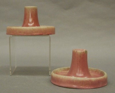 Pr Fulper Pottery candlesticks: A pair of 20th century Fulper Art Pottery candlesticks. Low, saucer base designs in a Plum Matte glaze. Impressed vertical "Fulper" marks. Slight surface wear. Each 3" high. ESTIMATE $50-75