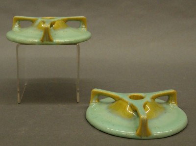 Pr Fulper Pottery candlesticks: A pair of 20th century Fulper Art Pottery candlesticks. Low, designs with three buttress handles in a Brown/Green glaze. Stamped vertical "Fulper" marks. Slight surface wear. Each 5 1/2" diameter. EST