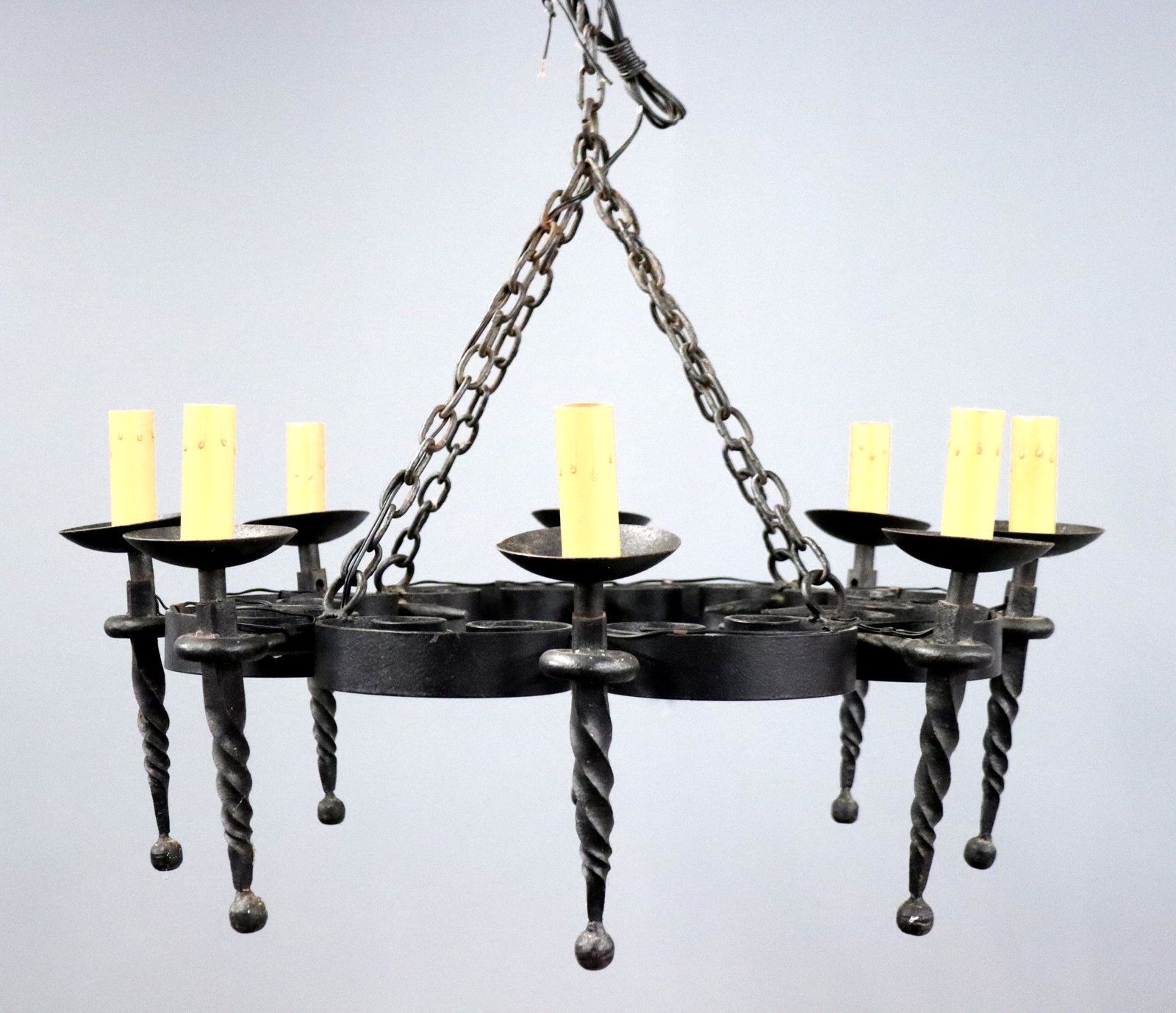 French Wrought Iron Chandelier: An early 20th century French Wrought Iron chandelier. Circular form with eight arms and scrollwork design. Black painted finish with some wear, requires rewiring. Approx 31" diameter x 17" high. ESTIM