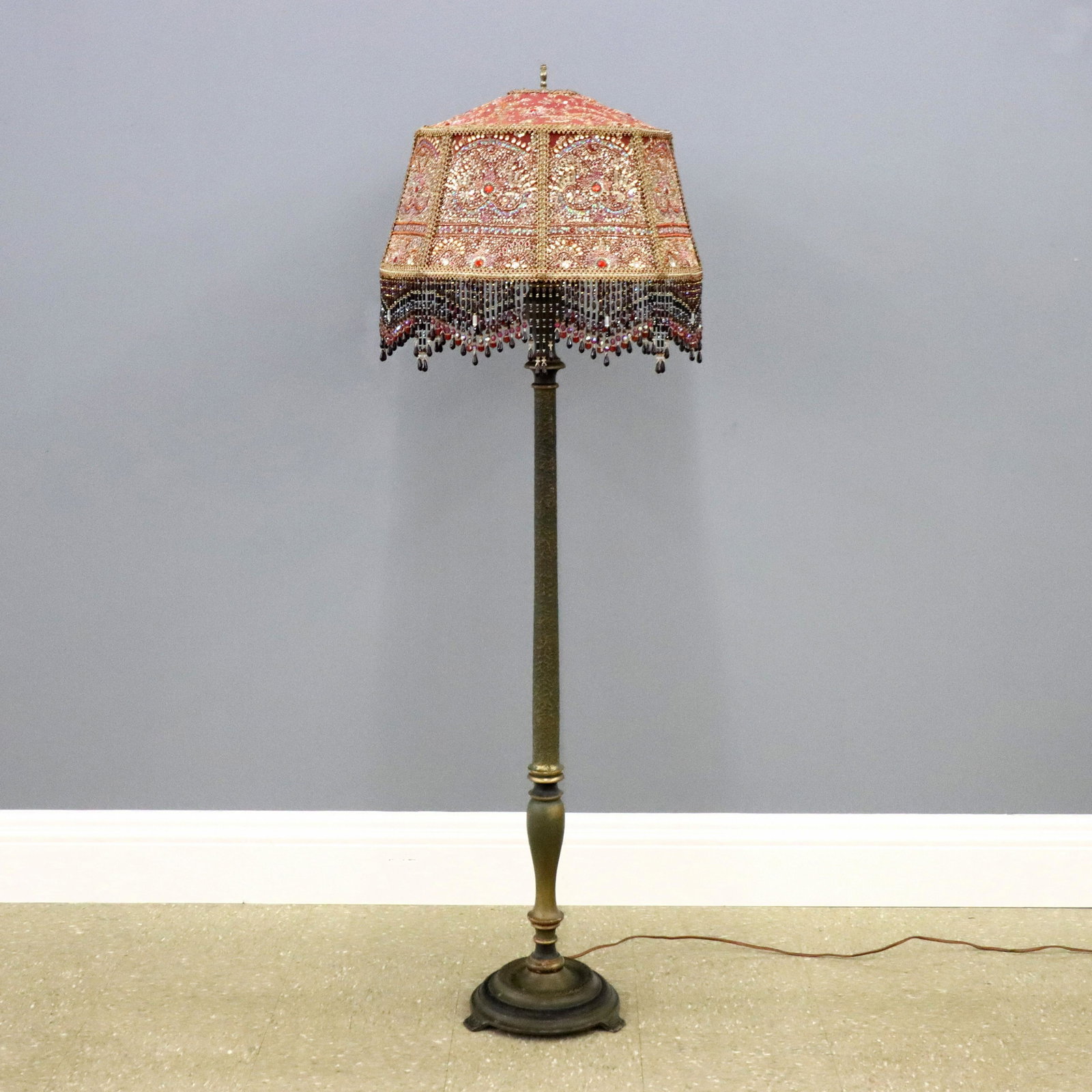 Art Deco Floor Lamp: A 1930's Art Deco Period floor lamp. Turned wooden stem with circular Bronze base and silk beaded shade. Original painted finish with minor loss, shade replaced. 61" high. ESTIMATE $200-300