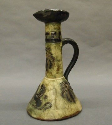 Guerin Cider pitcher: A 20th century Belgian Modernist Cider jug by Roger Guerin. Tall body with flared rim and foot, incised multi color glaze decoration and applied handle. Impressed and incised marks. Slight wear. 12 1/