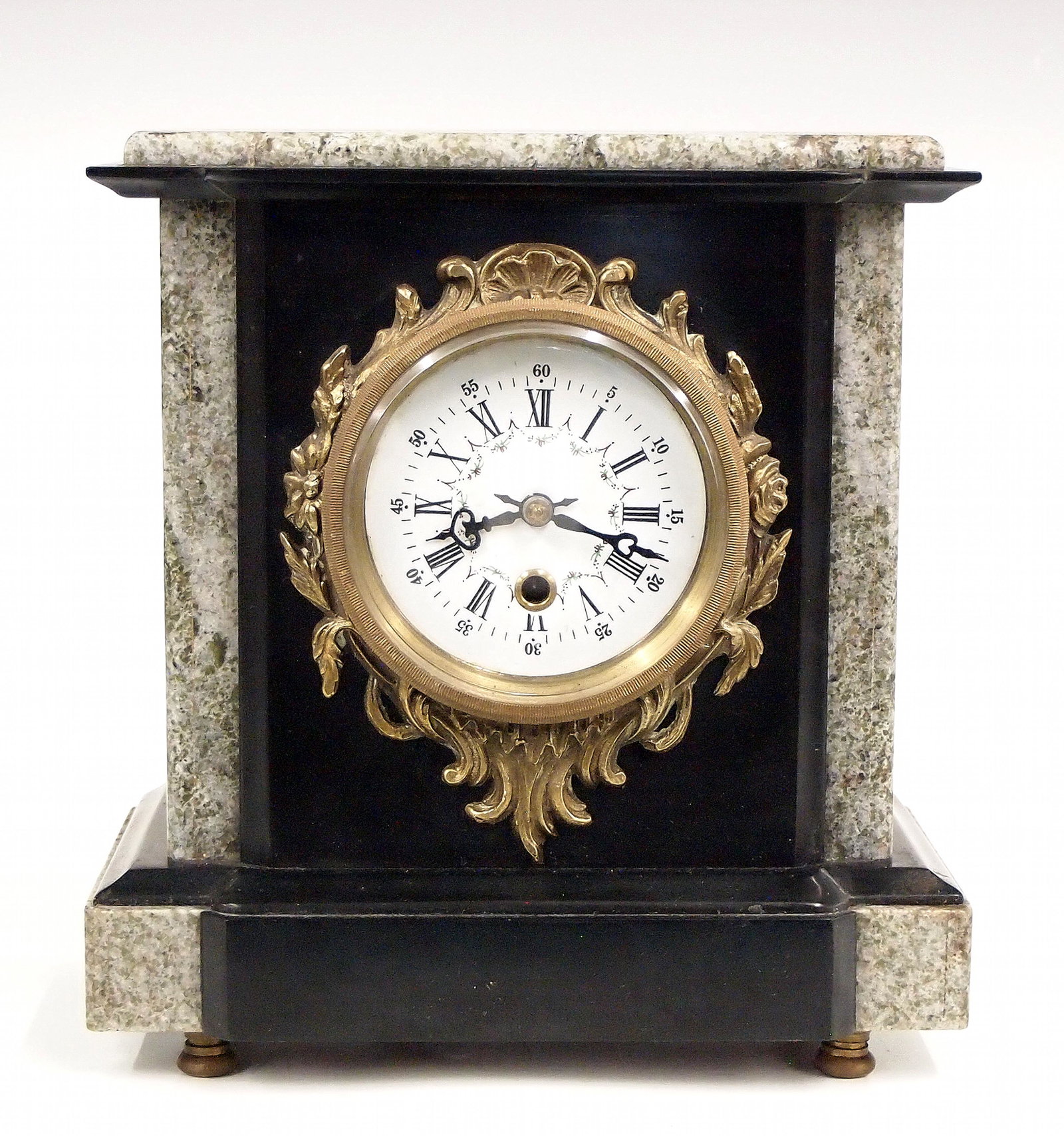 Slate Mantel Clock: A turn of the century mantel clock. 8-day time only movement with a porcelain dial and Roman numerals. Shaped Slate case with inlaid Marble and Gilt Bronze details. Minor wear. 9" high. ESTIMATE $50-7