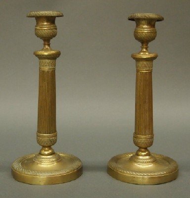 French candlesticks: A pair of late 19th century French Brass candlesticks. Engine turned detail with tapered reeded stems and round bases. Some wear, minor denting. Each 9 3/4" high. ESTIMATE $200-400