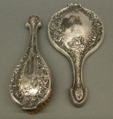 Art Nouveau mirror & brush: A turn of the century Art Nouveau Silver plated hand mirror and matching brush. Some wear. Up to 10" long. ESTIMATE $50-75