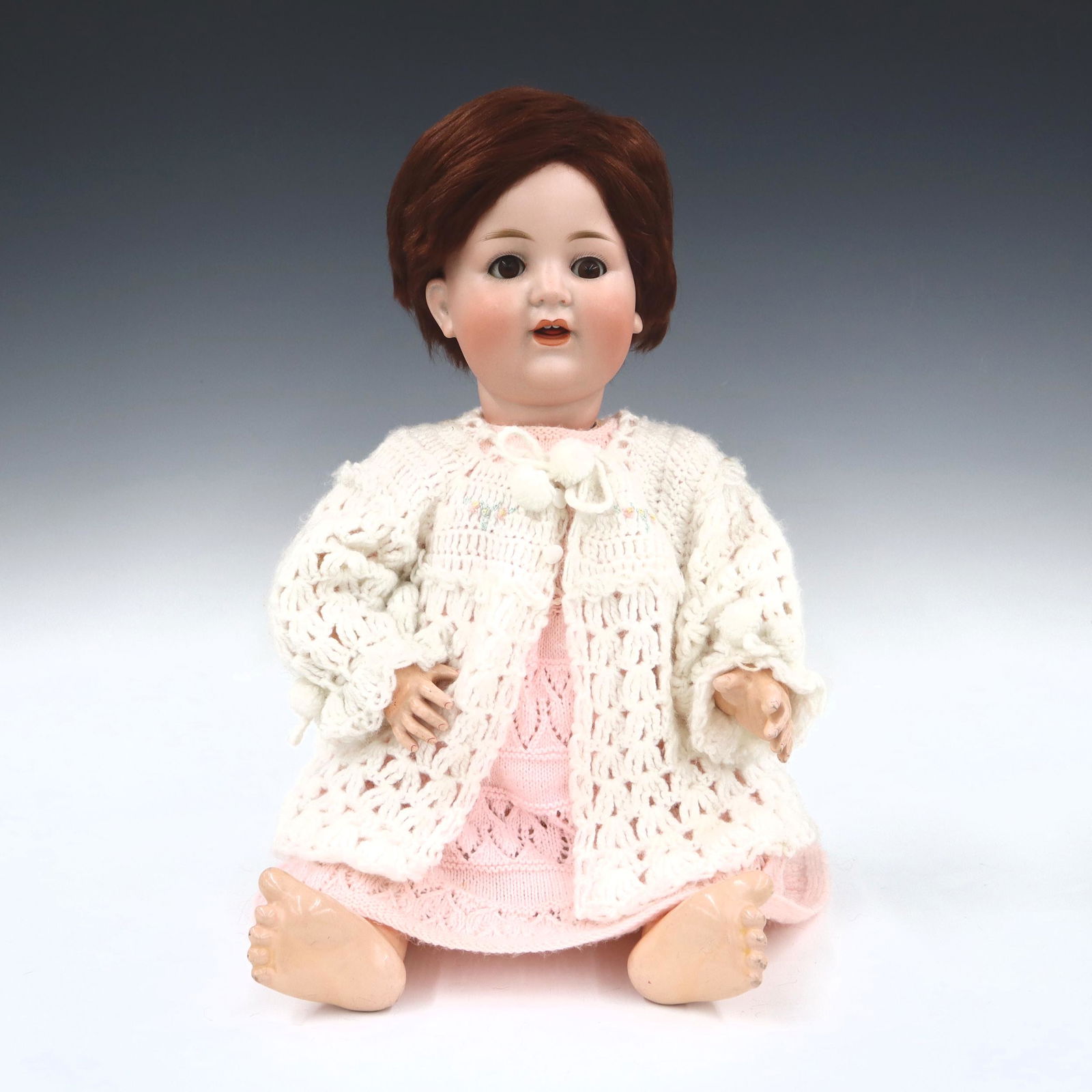 German Bisque Mechanical Doll: A turn of the century German mechanical talking doll. Key-wind mechanism at side, moves arm and talks. Bisque socket head with Brown hair, sleep eyes, open mouth with teeth, and painted detail. On a j