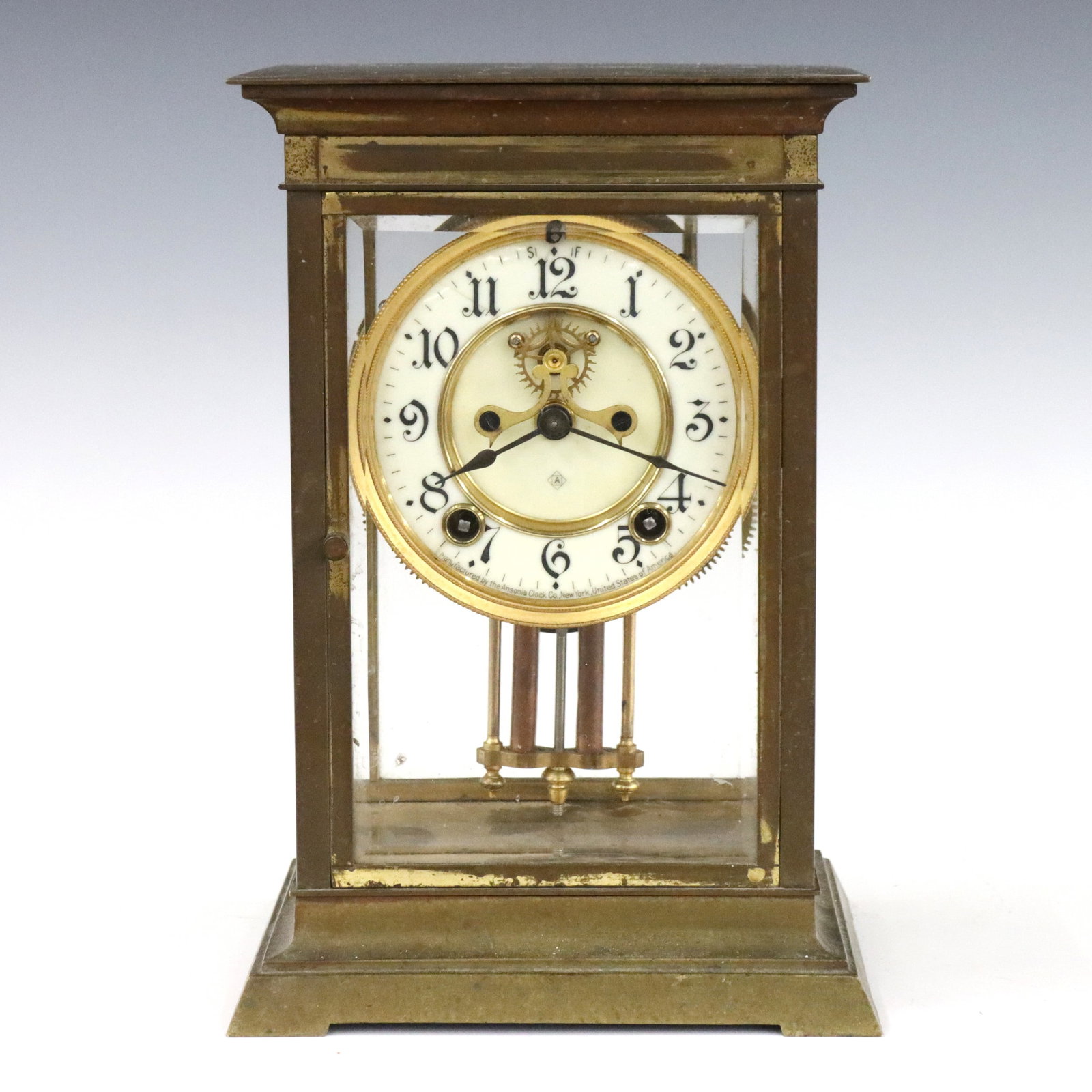 Ansonia Crystal Regulator: An early 20th century Ansonia Crystal Regulator. 8-day time and strike movement with two part porcelain dial, Arabic numerals and visible jeweled escapement. Brass case with beveled glass panels. Some