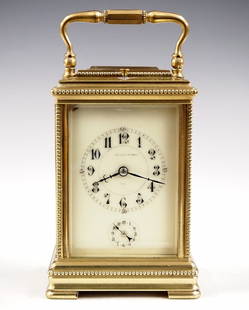 French Carriage Clock: A turn of the century French Carriage clock. 8-day movement with Petite Sonnerie strike and Grand Sonnerie repeat, porcelain dial with Arabic numerals and subsidiary alarm set dial. Brass case with be