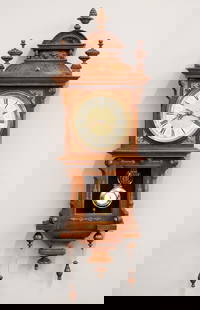 Junghans Wall Clock: A turn of the century Junghans wall clock with unusual pull string winding. 8-day spring driven time and strike movement with engraved Silvered chapter dial, Arabic numerals and gridiron pendulum