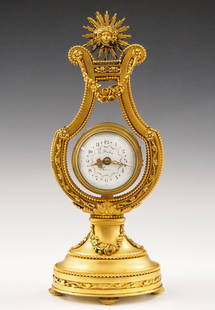 French Bronze Lyre Clock: A turn of the century French Gilded Bronze Lyre clock by "F Deux, Paris". 8-day time only movement with platform escapement, convex porcelain dial with Arabic numerals, Gilded filigree hands and