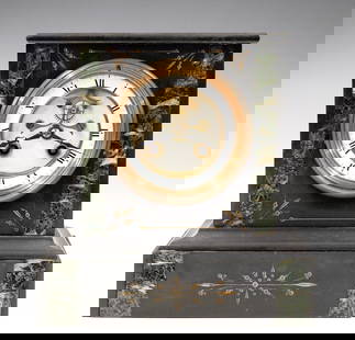 French Marble Clock: A turn of the century French Marble mantel clock. 8-day time and strike movement with visible escapement, two part porcelain dial and Roman numerals. Black Marble case with Verde accents and Gilded de