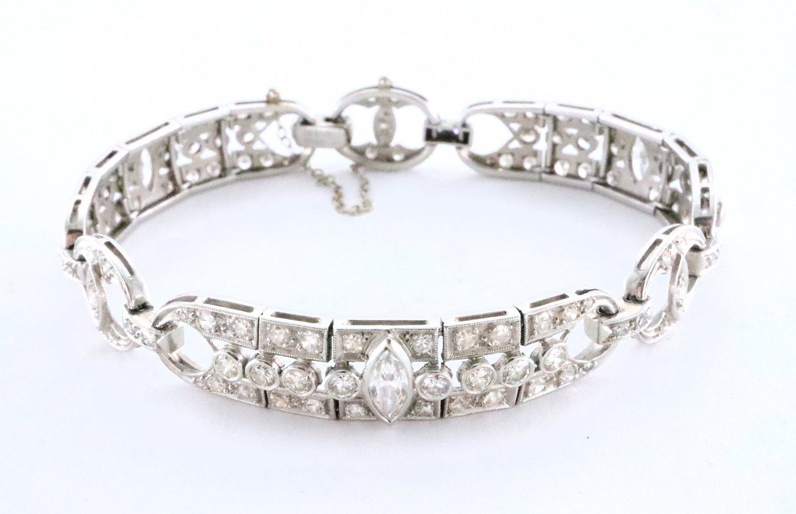 Art Deco Platinum & Diamond Bracelet: An early 20th century Art Deco Period Platinum and Diamond bracelet. Three articulated milgrain links each consisting of a bezel set 4 x 8mm marquis diamond, approx. 1.5 cttw, flanked by eight bezel s