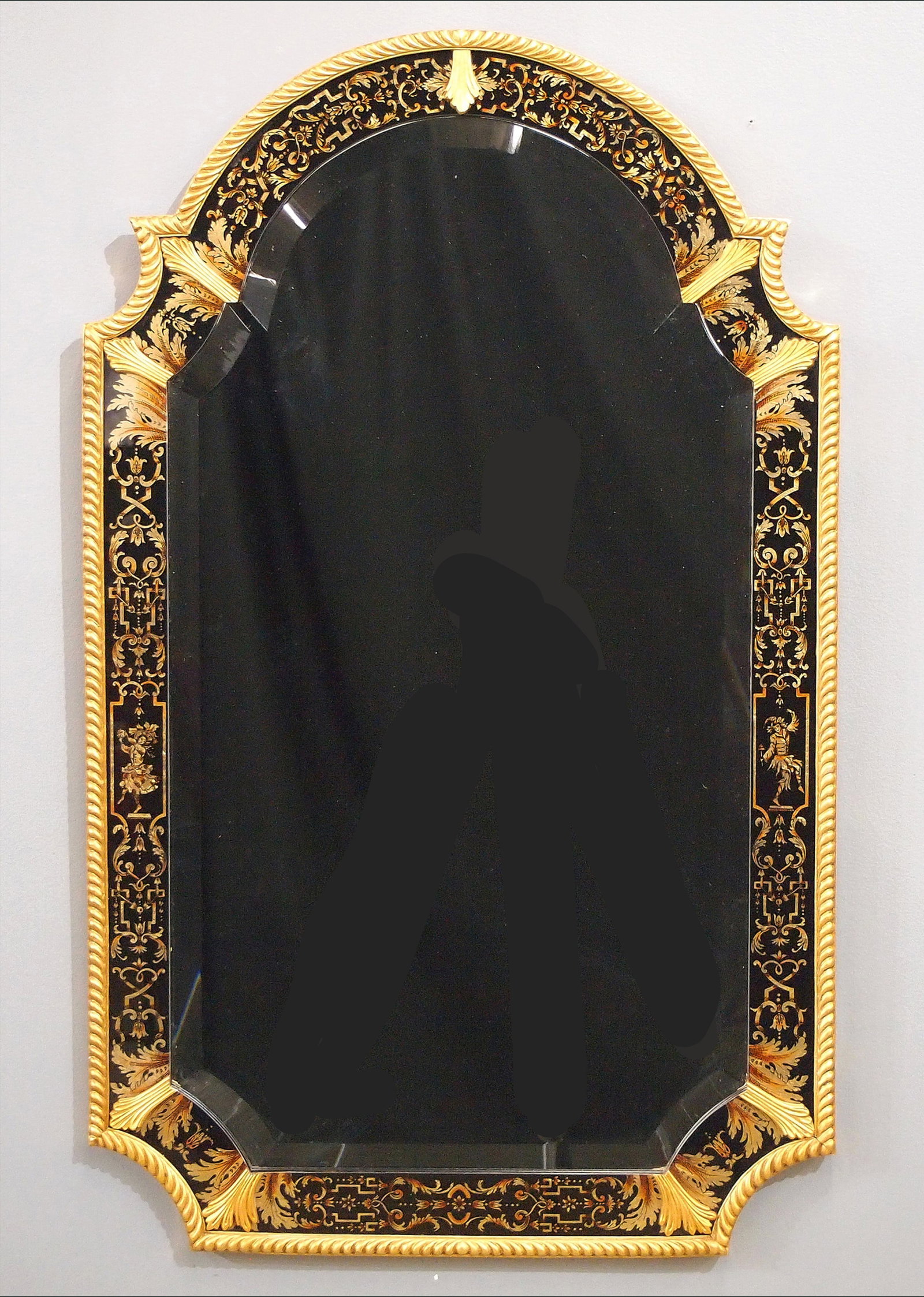 Baker Wall Mirror: A Baker wall mirror from the "Stately Homes of England and Scotland" collection. Shaped beveled mirror and reverse painted glass liner within a Gilded frame with roped detail. Slight wear, minor edge 
