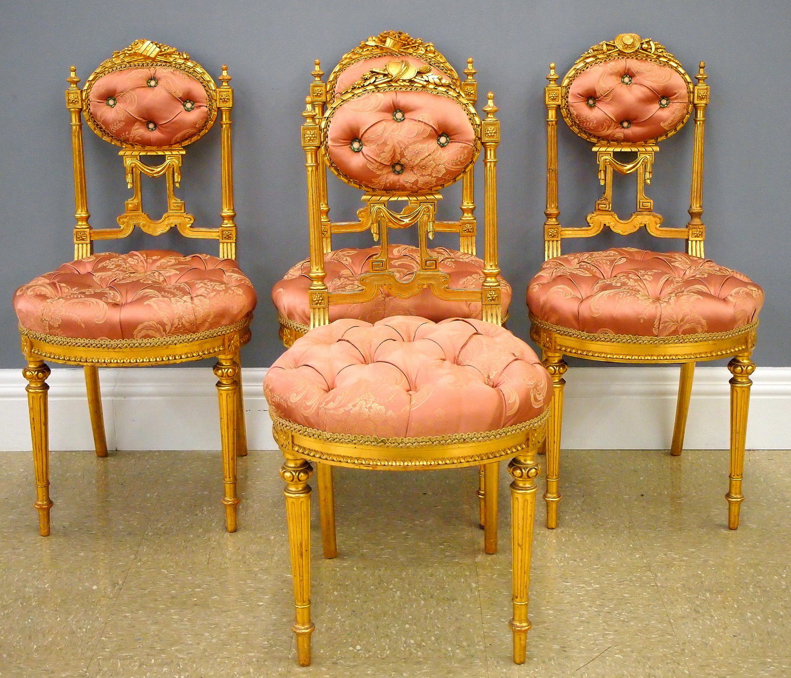 4 French Gilded Sidechairs: Four late 19th century French Louis XVI style parlor sidechairs. Oval upholstered backs with individually carved allegorical crests and frames with fluted supports and upholstered seat on turned legs 