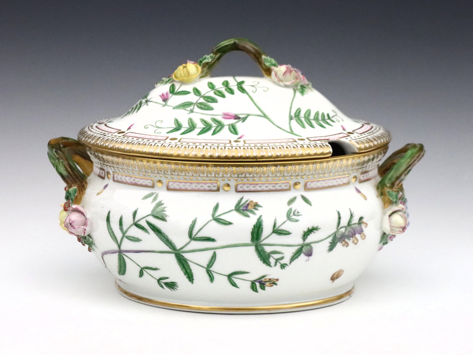Royal Copenhagen Flora Danica Tureen: A 20th century Royal Copenhagen "Flora Danica" pattern porcelain soup tureen. Oval form with floriform handles, hand-painted floral decoration and Gilded accents. Printed "Royal Copenhagen Denmark" ma