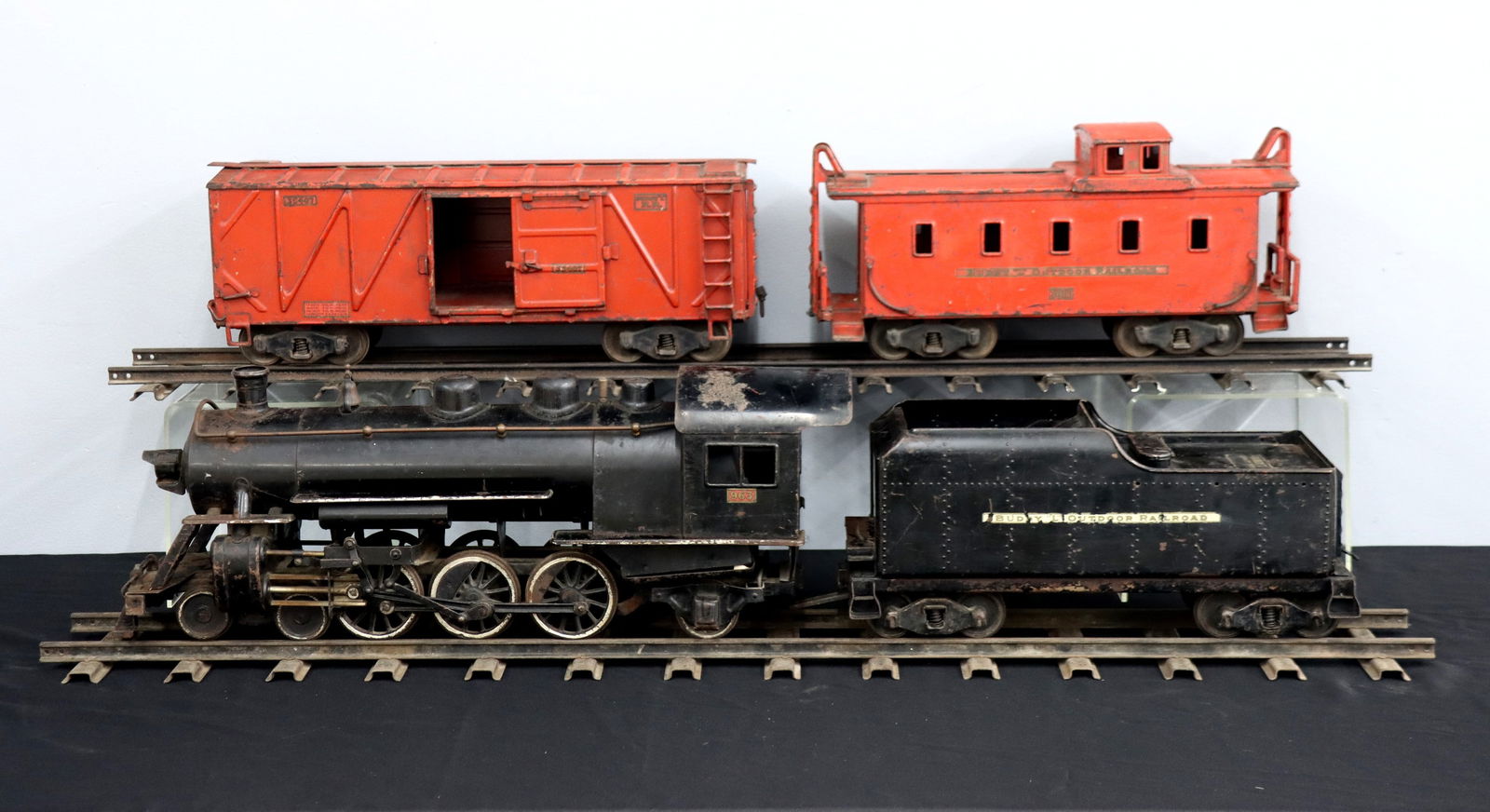 Moline Buddy L Line Train Set: A 1920's Buddy L Outdoor Line pressed steel freight train set. Includes a 26" locomotive, a 17" tender, an 18" caboose, a 21" freight car, and two 4' straight sections of track. Original stenciled "Th