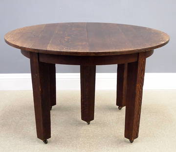 G. Stickley Dining Table: A turn of the century Gustav Stickley Arts and Crafts Period dining table, c. 1910. Model 632, quartersawn Oak construction with a 48" circular top and conforming apron on five legs with casters. Incl