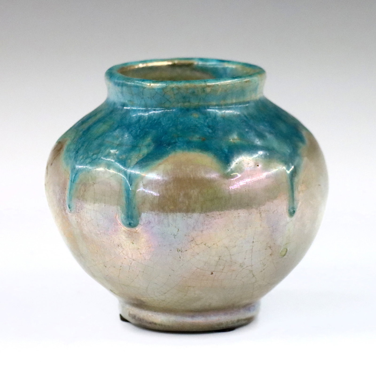 Pewabic Pottery Vase: An early 20th century Pewabic Art Pottery vase. Bulbous form with tapered shoulder and Turquoise drip glaze over an Iridescent Gold ground. Circular impressed "Pewabic Detroit" mark. Crazing, minor su