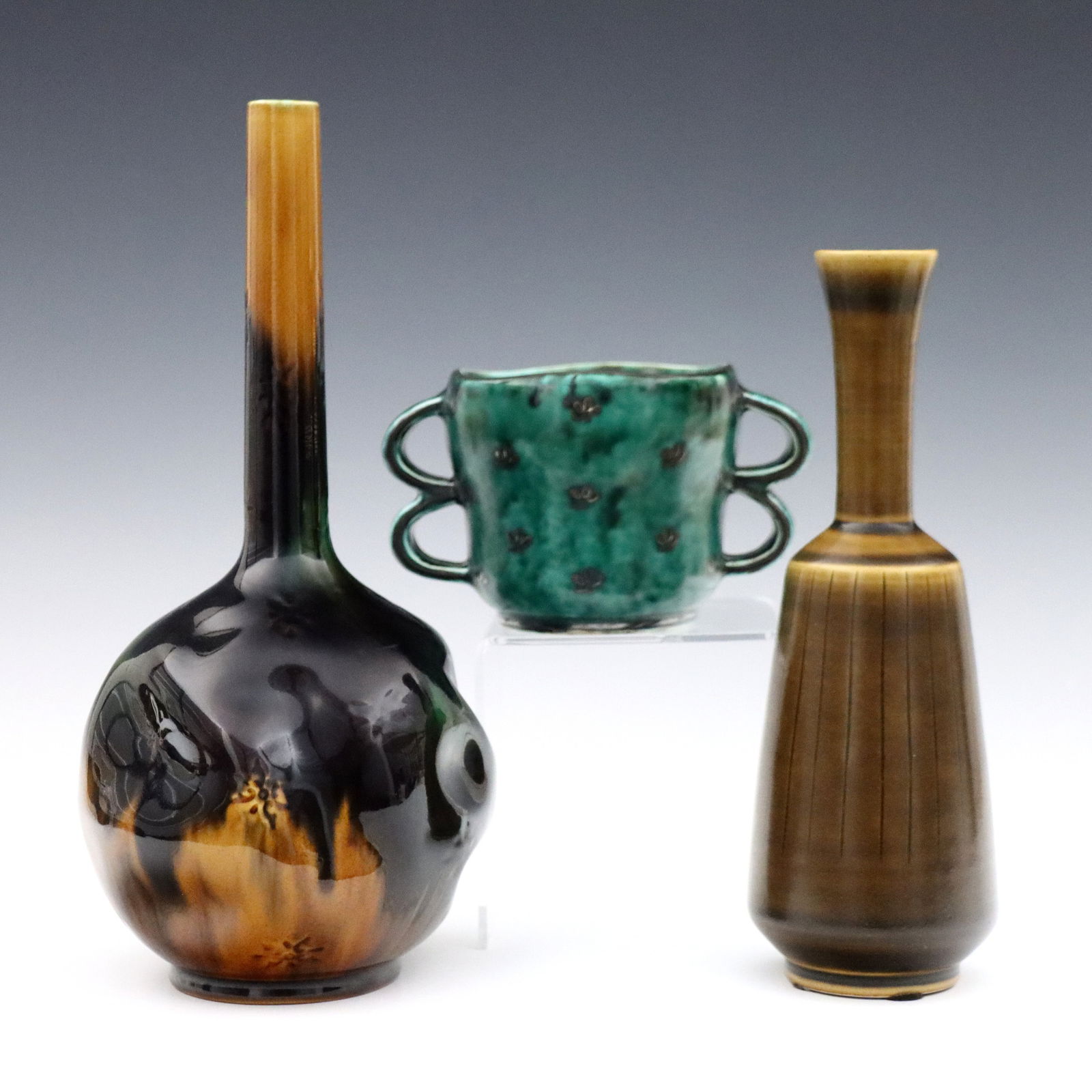 3 pc Swedish Art Pottery: Three pieces of early 20th century Swedish Art Pottery. Includes a Rorstrand bottle vase with bulbous, dimpled body and Green/Brown glaze, a Hoganas bottle vase with painted linear decoration and Brow