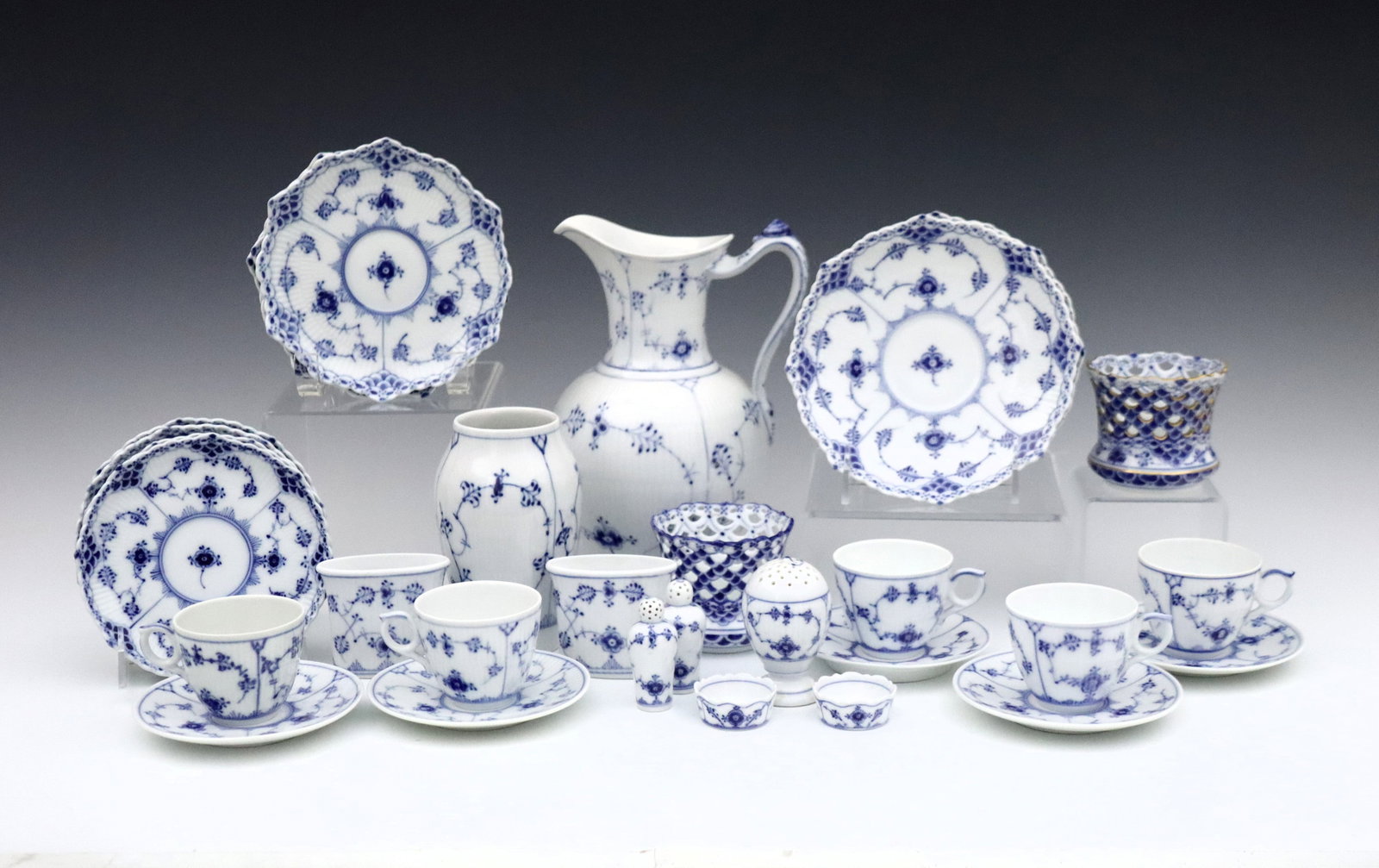 32 pc Royal Copenhagen Tableware: Thirty pieces of 20th century Royal Copenhagen "Blue Fluted" porcelain tableware. Includes a water pitcher, vase, two votives, two cigarette holders, five coffee cups with saucers, nine small dishes, 