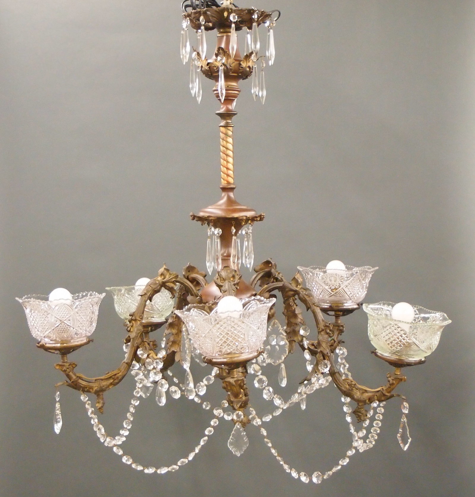 American Brass Chandelier: A late 19th century American Brass chandelier. Five scrolled arms with foliate detail and Crystal drops. Older finish with wear and some alteration. Approx. 36" diameter x 38" high overall. ESTIMATE $