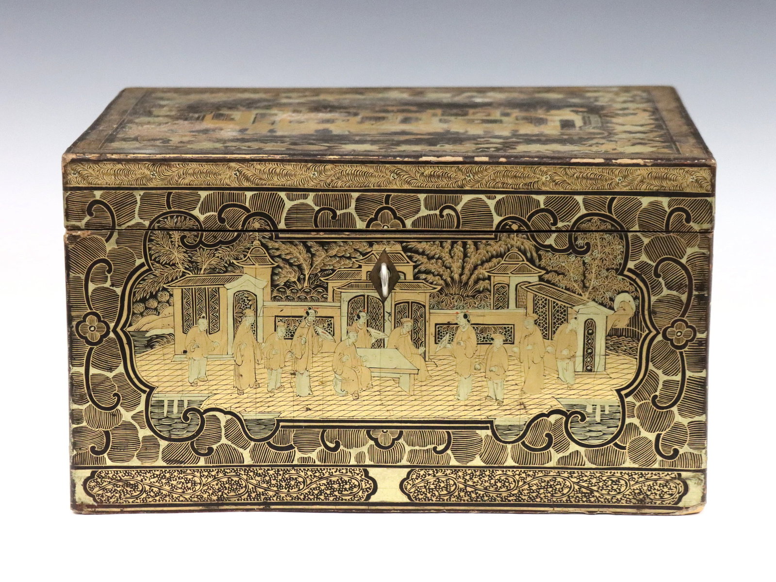 Chinese Tea Box: A 19th century Chinese tea box. Lacquered wooden case, rectangular form with Gilded decoration depicting a Court scene. Hinged top opens to a reveal an interior Paktong box with hinged cover and engra