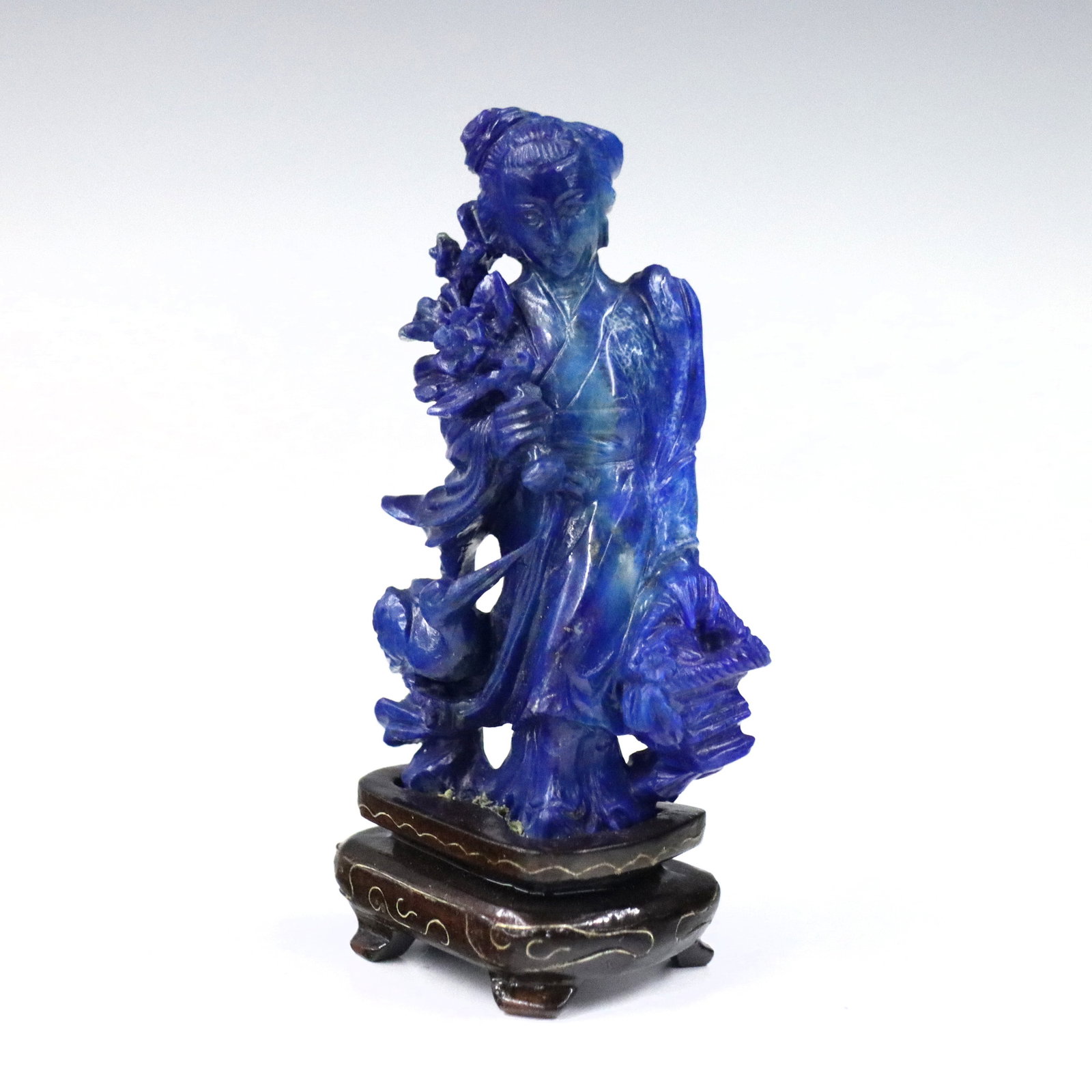 Chinese Lapis Lazuli Figure of Guan Yin: A 20th century miniature Chinese carved Lapis Lazuli figure of Guan Yin. Depicted standing with bouquet in hand and stork below. Slight wear and fissures in stone. Figure is 3 1/4" high, 3 3/4" high o