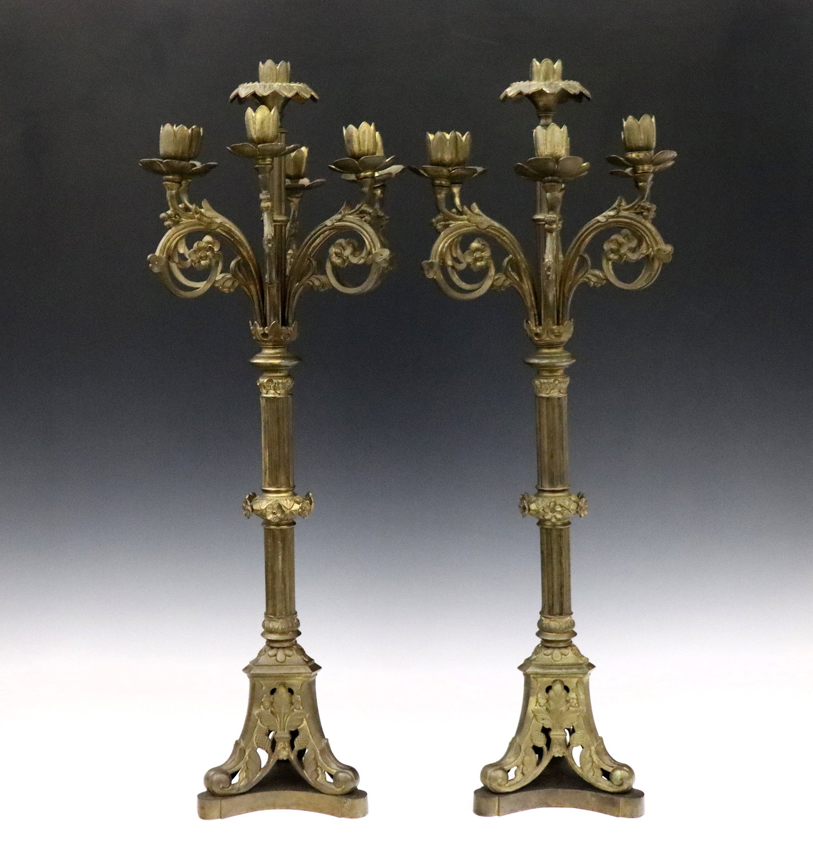 Pr French Bronze Candelabra: A pair of turn of the century French Bronze candelabra. Features six scrolled floral arms surrounding a central raised light over a fluted stems and pierced tri-pod base. Original Gilded finish with w