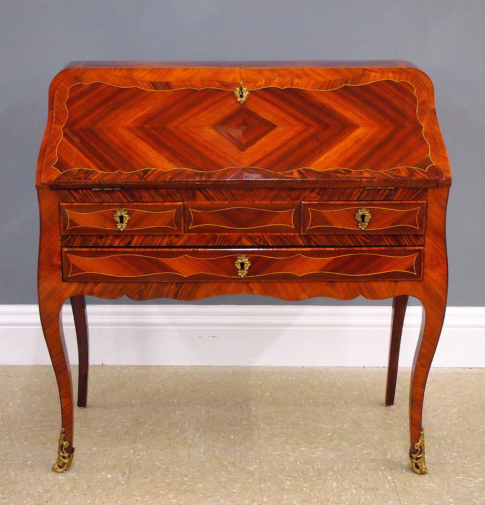 French Ladies Desk: An early 20th century French Louis XV style ladies desk. Mahogany and Kingwood construction features a fold down writing surface which opens to reveal a stepped interior fitted with small drawers, two
