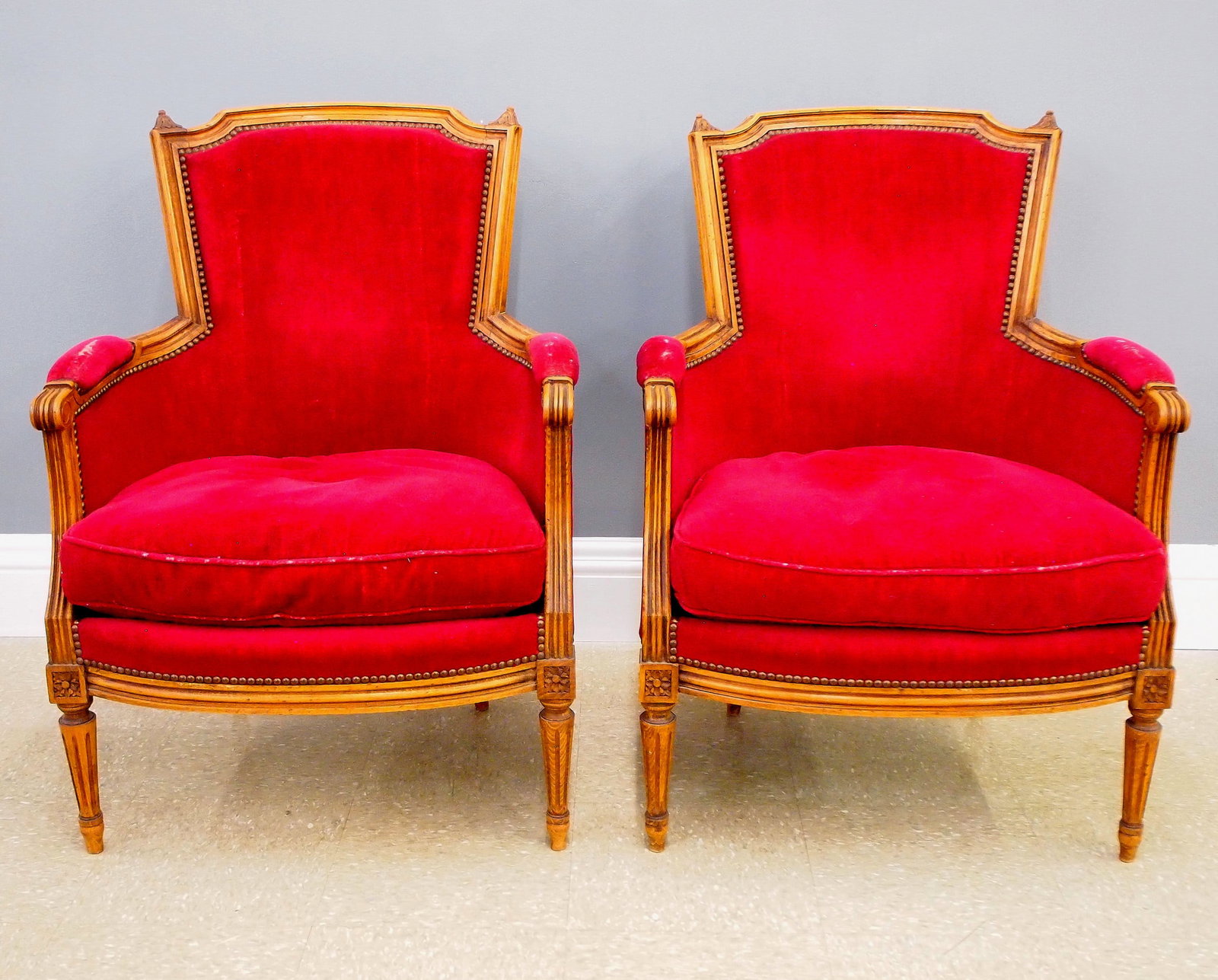 Pr Louis XVI Style Bergeres: A pair of 19th century French Louis XVI style bergeres. Fruitwood construction with carved detail, velvet upholstered backs, arms rests and down cushion seats on tapered legs with fluted detail. Old f