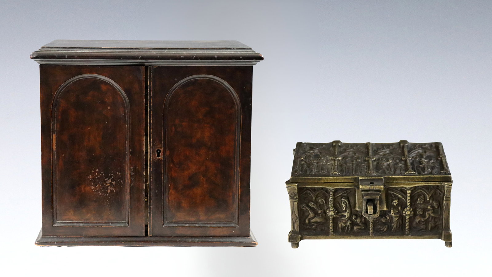 2 Jewelry Boxes: Two 19th century jewelry boxes. Includes a German Gilded Bronze jewelry casket with Gothic Biblical design, and a British Figured Mahogany jewelry chest with two doors that open to reveal three gradua