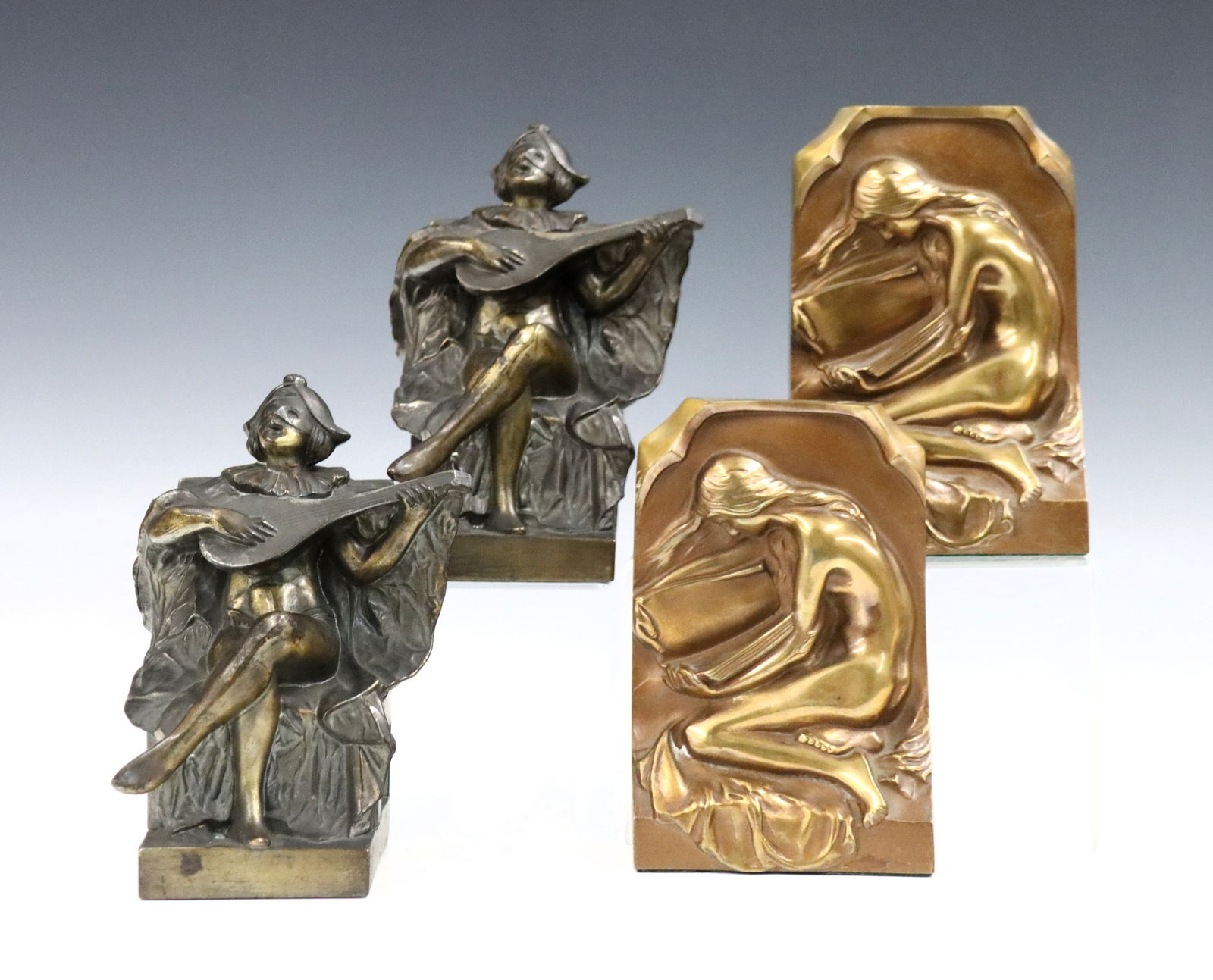 Pr Bronze Figural Bookends: Two pairs of early to mid 20th century figural Bronze bookends. Includes a set depicting an Allegorical nude female depicting the Arts, and a set depicting a seated jester playing music. Some wear to