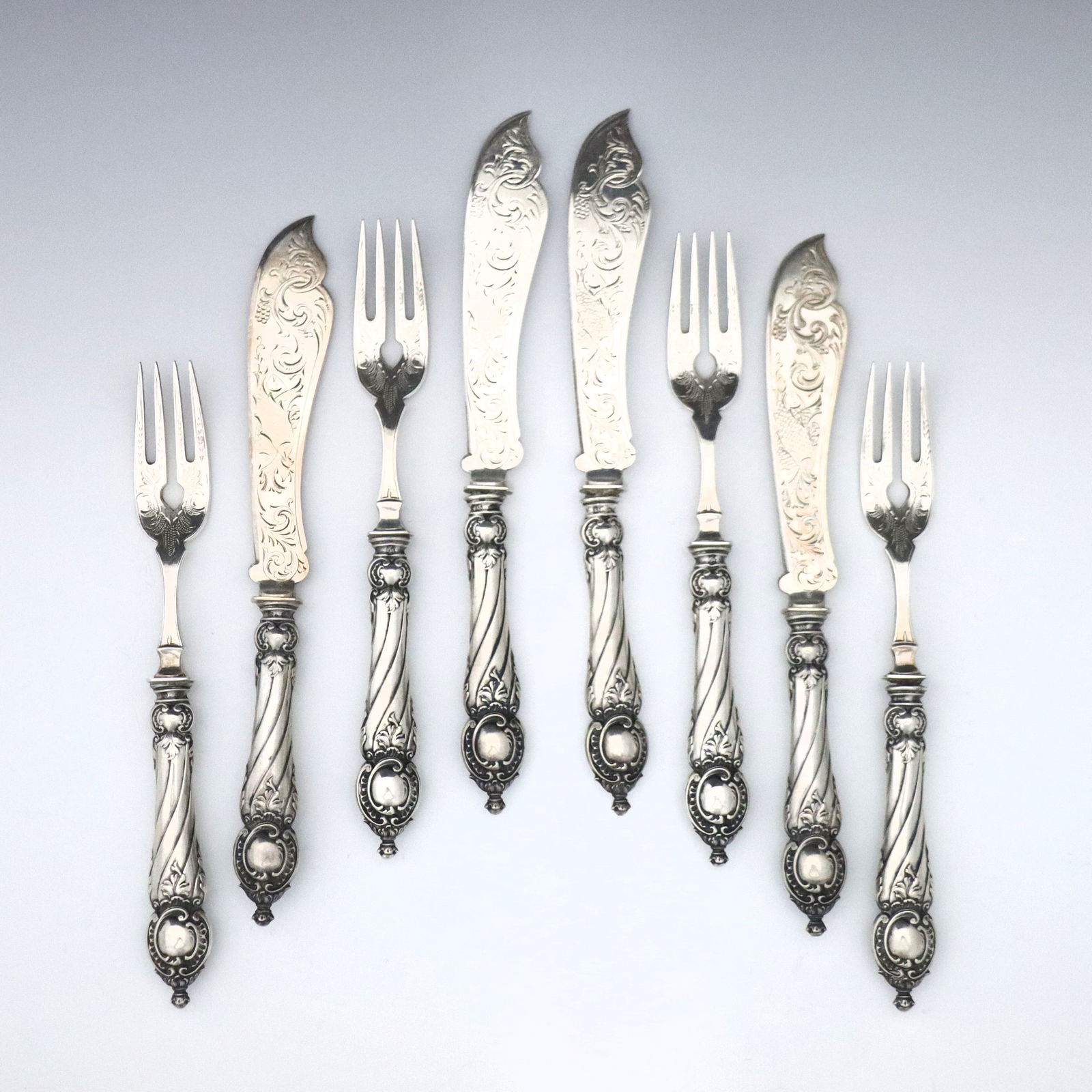 24 pc German Silver Fish Service: Twenty-four pieces of 19th century German .800 Silver fish service flatware. Includes twelve fish knives and twelve forks with decorative hollow handles and engraved fish design. Impressed "800" with