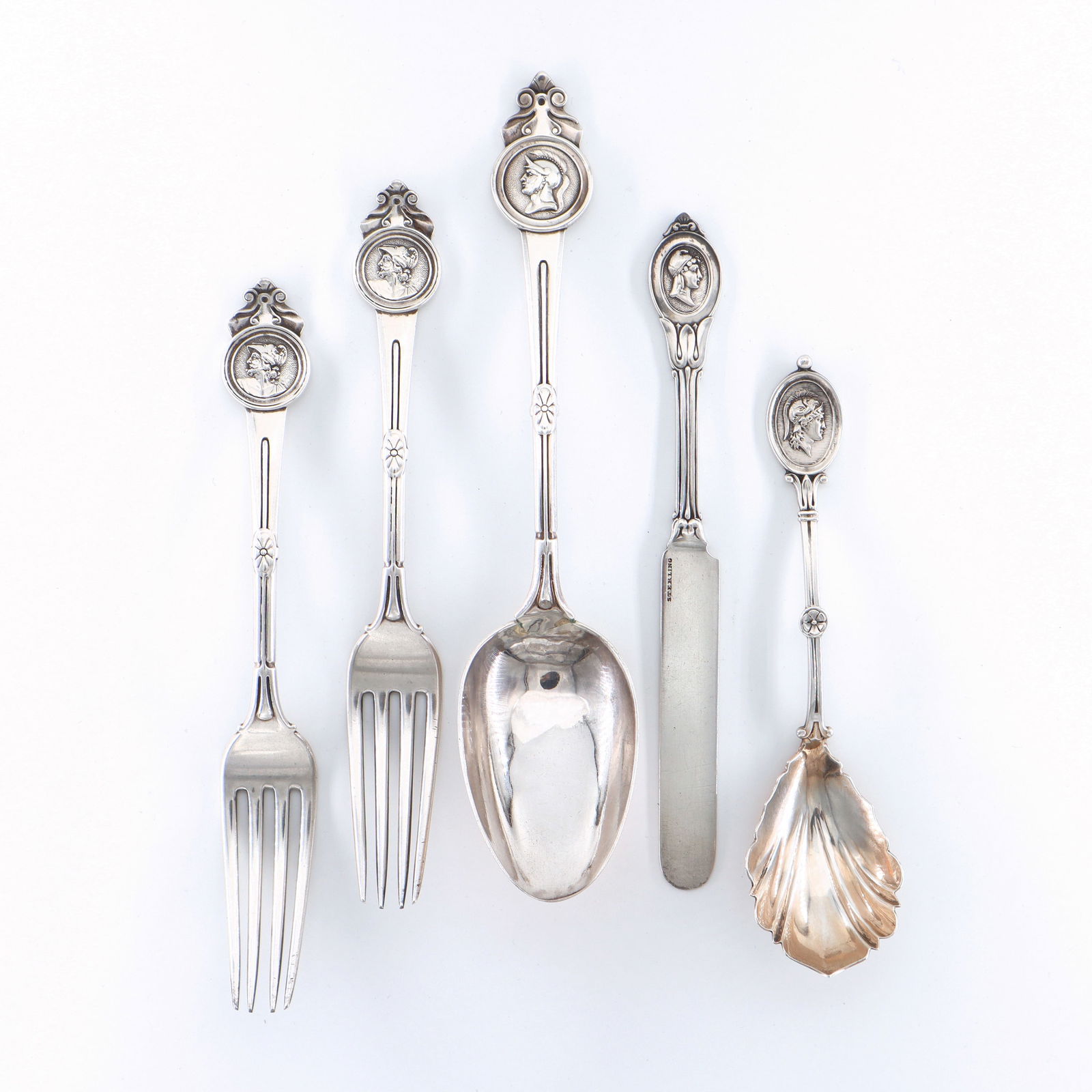 5 pc American Sterling Medallion Flatware: Five pieces of 19th century American Sterling Silver Medallion pattern flatware by various makers. Includes a serving spoon and two forks by Gorham, with a sugar spoon and butter knife. Each with impr