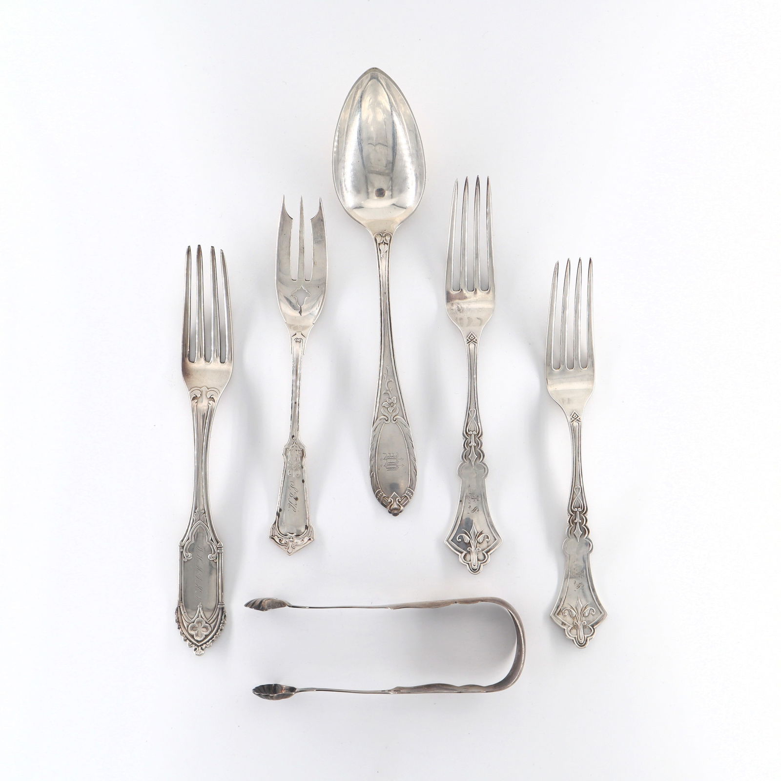 6 pc American Coin Silver Flatware: Six pieces of 19th century American Coin Silver flatware by various makers. Includes forks, a serving spoon and tongs. Each with impressed marks. 9.26 troy ozs total. Minor surface wear, monogrammed.