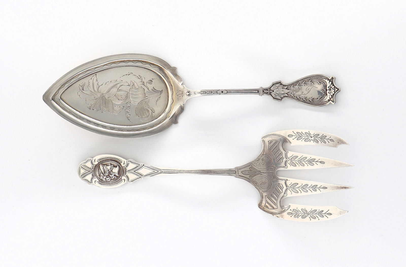 2 American Coin Silver Serving Utensils: Two 19th century American Coin Silver serving utensils with engraved decoration. Includes a Medallion pattern serving fork and a pie server. Each with impressed "Coin" marks. 3.61 troy ozs total. Mino
