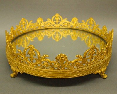 Bronze plateau: A turn of the century Bronze plateau with mirrored interior. Finley detailed Gilded Bronze gallery with Angels holding flower baskets within wreaths and scrolled foliate border with circular mirror an