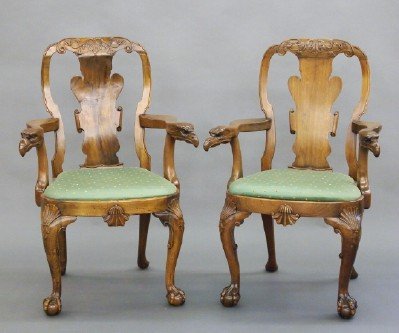 Pr of Walnut armchairs: A pair of 20th century Carved Walnut armchairs. George I style with carved foliate crests, fiddle shaped splats, shaped arms with Eagle heads, compass seats, and cabriole legs with shell carved knees 