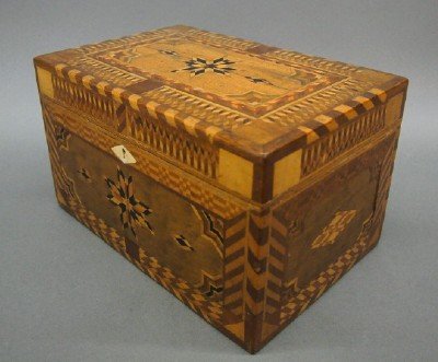 Inlaid sewing box: A turn of the century Prison Art inlaid sewing box. Extensive multi wood geometric inlay with a fabric lined interior with mirror. Old finish with some wear and minor damage. 11 3/4" long. ESTIMATE $2