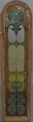 Stained glass window: A turn of the century Stained glass window. Arch top with multi color leaded glass in a foliate design. In the original sash with some cracked panels. 18 x 73 1/2" high. ESTIMATE $200-300