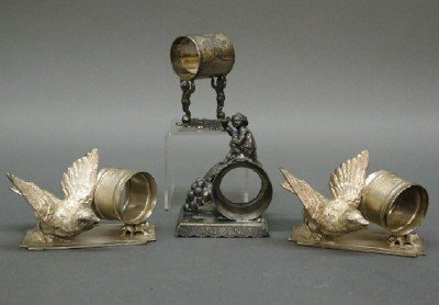 4 Silver Plated napkin rings: Four early 20th century Silver plated napkin rings. Includes a pair with Figural songbirds and two with cherub figures. Some with wear. Up to 4" high. ESTIMATE $200-400